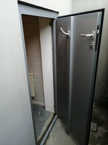 Flood-resistant door opened inward at a low opening